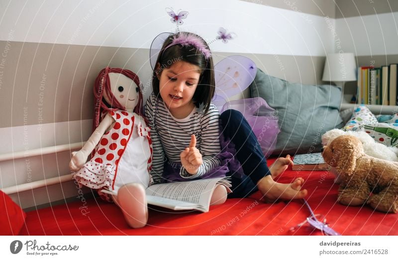 Girl disguised reading a book to her doll Beautiful Playing Reading Bedroom Child To talk Human being Woman Adults Friendship Book Butterfly Wing Toys Authentic