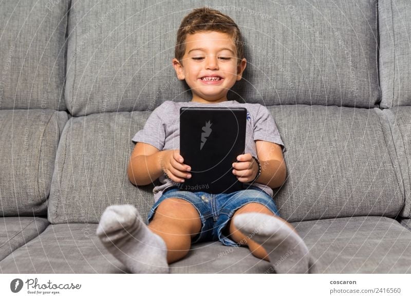 Little boy using a tablet Happy Leisure and hobbies Playing Sofa Child School Computer Notebook Screen Technology Internet Baby Toddler Boy (child) Infancy