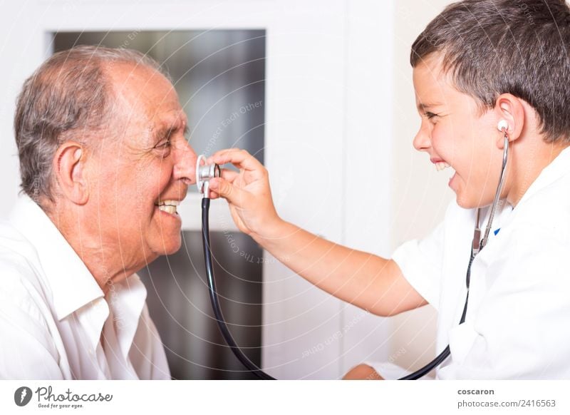 Kid examines his grandfather using stethoscope. Funny game Face Health care Illness Medication Playing Child Profession Doctor Hospital Career Human being