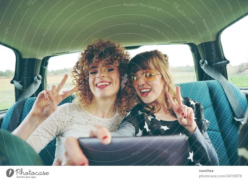 Two happy friends in a car making a selfie Lifestyle Style Joy Hair and hairstyles Vacation & Travel Tourism Trip Adventure Freedom Cellphone Camera Technology