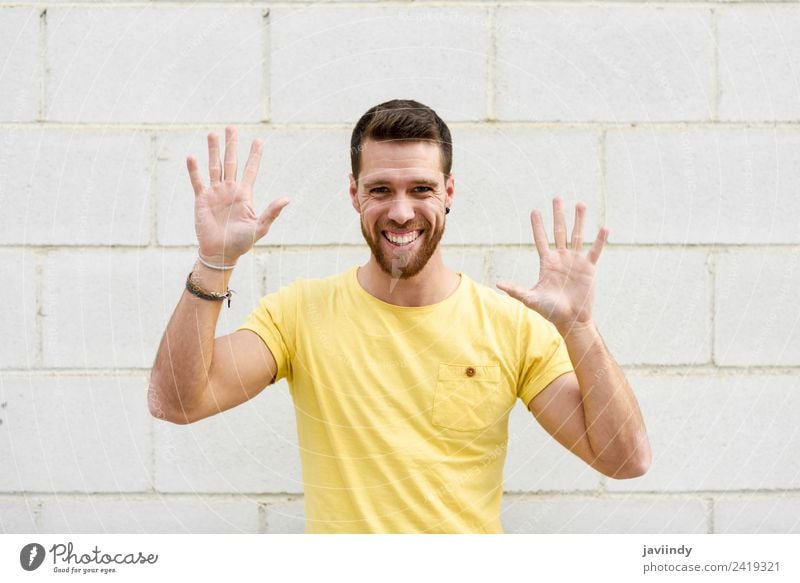Funny young man on brick wall with open hands Lifestyle Style Happy Human being Young man Youth (Young adults) Man Adults Hand 1 18 - 30 years Street Fashion