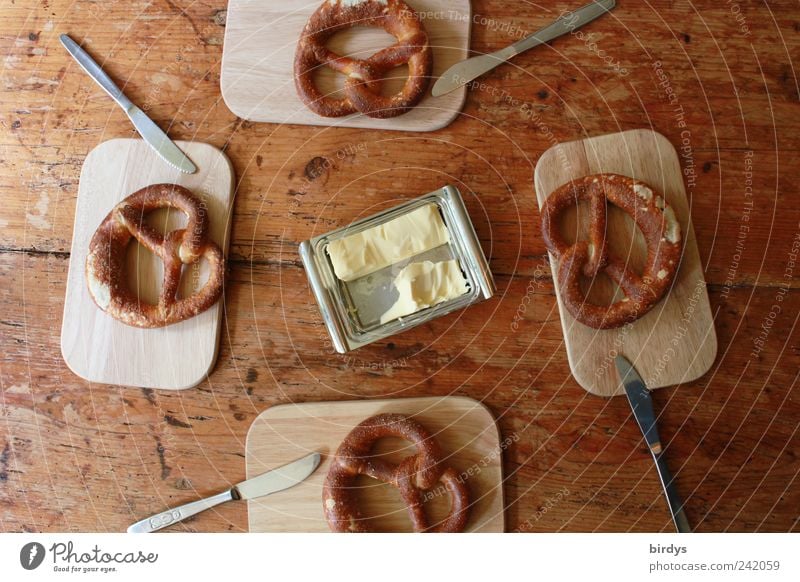 Pretzels with butter for 4 people Butter Baked goods Chopping board pretzel Breakfast Knives butter can Food Wooden table Bird's-eye view To enjoy Middle around