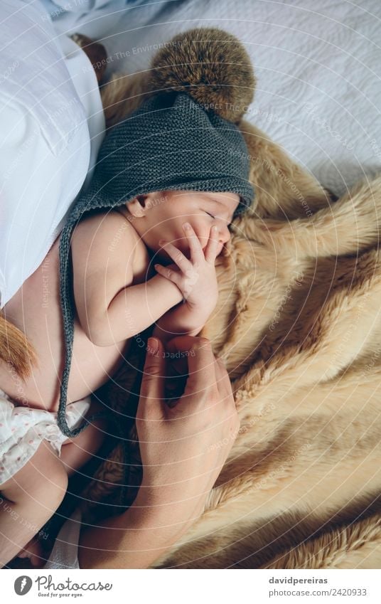 Newborn baby girl sleeping lying on bed next to mother's hand Beautiful Calm Bedroom Child Human being Baby Woman Adults Mother Family & Relations Hand Hat Love