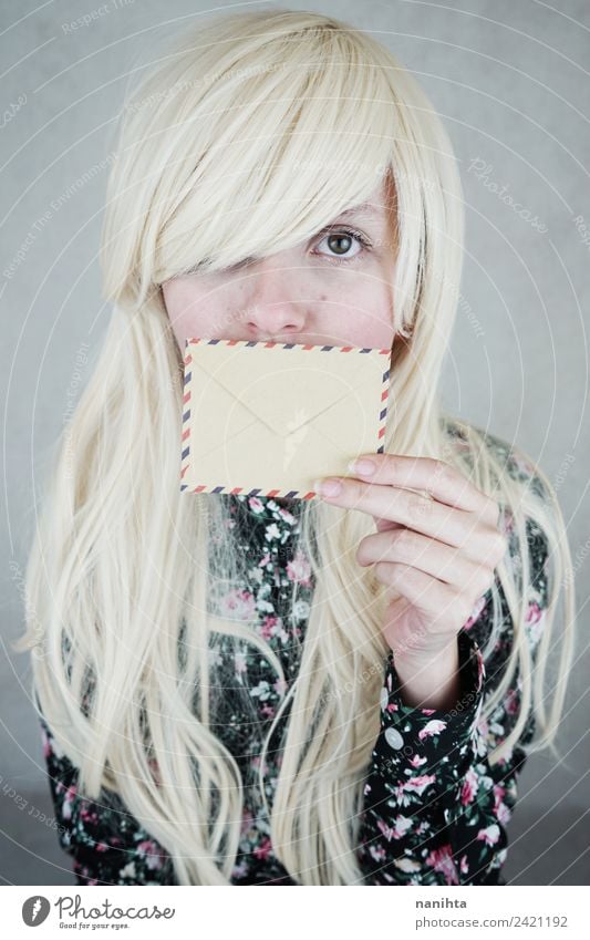 Young blonde woman covering her mouth with an envelope Design Hair and hairstyles Skin Face Mail Envelope (Mail) Addressee Invitation Sender Human being