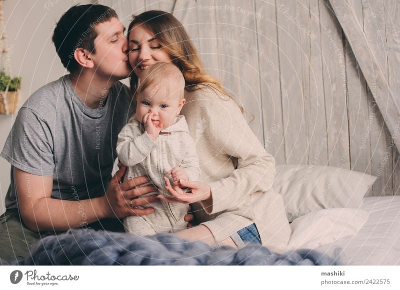 happy family playing at home on the bed Lifestyle Joy Bedroom Baby Parents Adults Mother Father Family & Relations Couple Infancy Hand Kissing Love Embrace