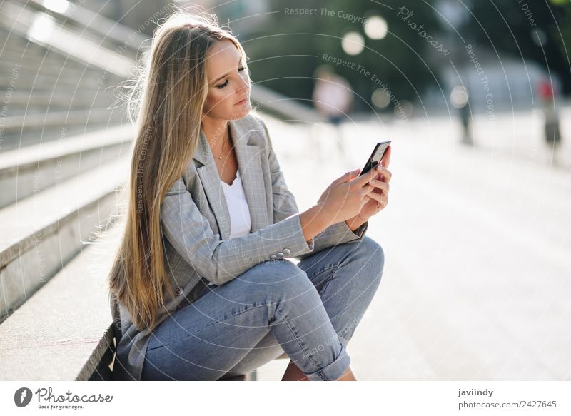 Blonde woman looking at her smartphone outdoors Lifestyle Style Beautiful Hair and hairstyles Telephone PDA Human being Young woman Youth (Young adults) Woman