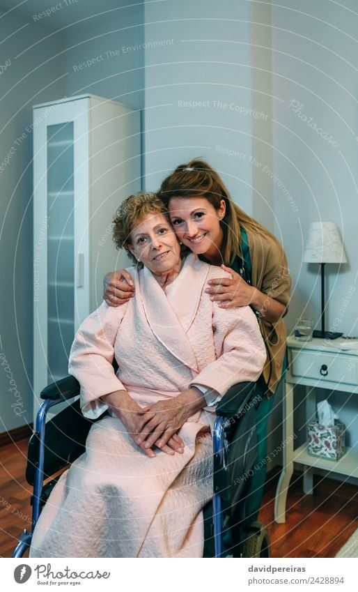 Female caretaker posing with elderly patient Beautiful Health care Illness Lamp Bedroom Doctor Hospital Human being Woman Adults Old Smiling Embrace Authentic