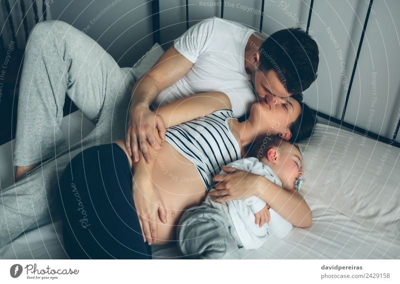 Pregnant kissing her partner with their son Happy Beautiful Life Relaxation Bedroom Child Human being Baby Toddler Woman Adults Man Parents Mother Father