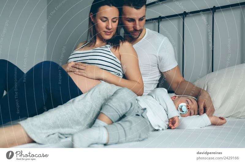 Pregnant woman with husband looking son Happy Beautiful Relaxation Calm Bedroom Child Human being Baby Toddler Woman Adults Man Parents Mother Father