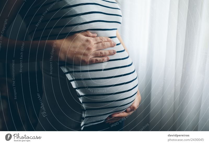 Pregnant woman holding her tummy Lifestyle Bedroom Parenting Human being Baby Woman Adults Mother Hand Wait Authentic Hope Pain Expectation Future