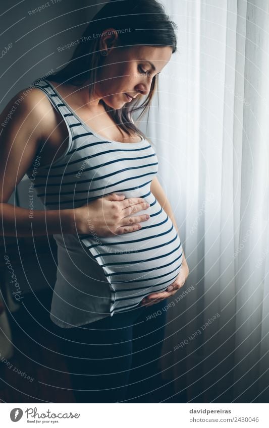 Pregnant woman looking her belly Lifestyle Beautiful Parenting Human being Baby Woman Adults Parents Mother Hand Think Love Growth Wait Authentic Serene