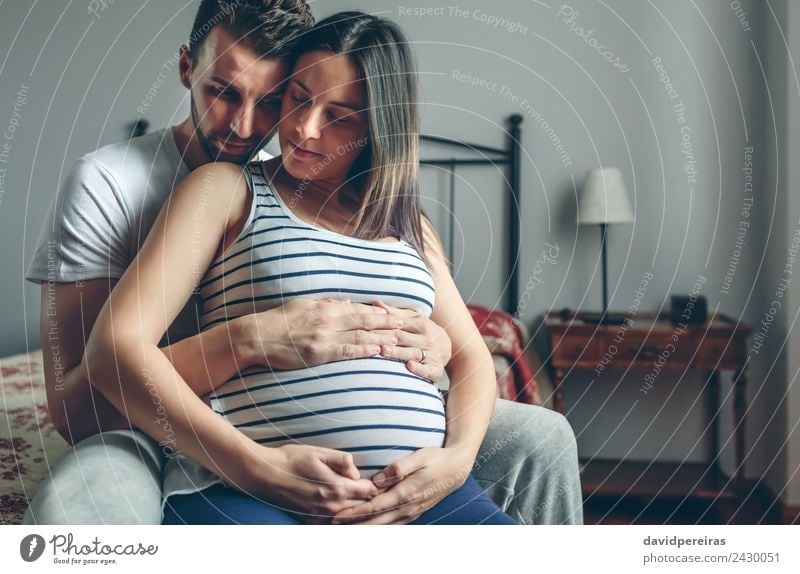 Pregnant woman embraced by her husband Calm Bedroom Human being Baby Woman Adults Man Parents Mother Father Family & Relations Couple Partner Hand Love Sit