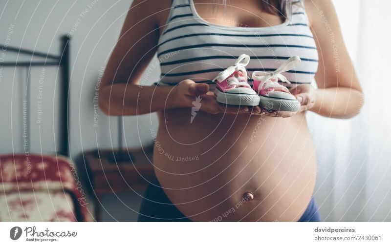 Pregnant showing baby sneakers Lifestyle Human being Baby Woman Adults Mother Footwear Sneakers Wait Authentic Naked Pink Anticipation Expectation