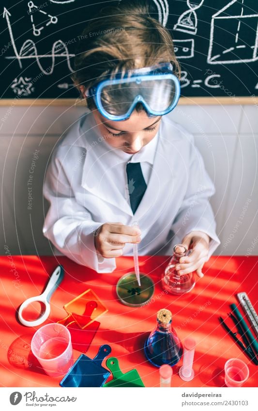 Serious kid playing with chemical liquids Bottle Playing Flat (apartment) Table Science & Research Child Classroom Laboratory Human being Boy (child) Infancy