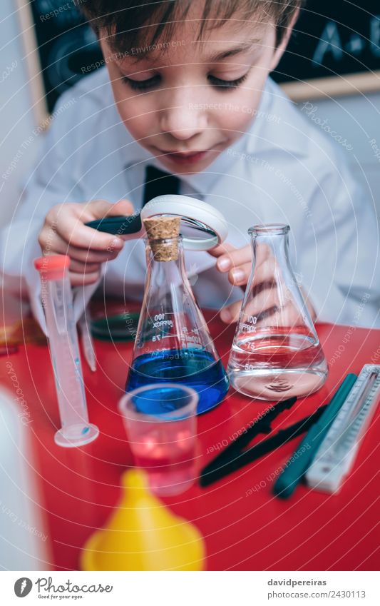 Happy kid looking liquid through magnifying glass Bottle Joy Playing Flat (apartment) Table Science & Research Child School Classroom Blackboard Laboratory