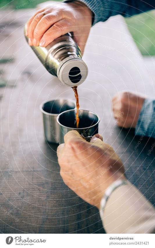 Senior couple hands pouring coffee from thermos Drinking Coffee Tea Lifestyle Relaxation Leisure and hobbies Table Human being Woman Adults Man Couple Hand Wood