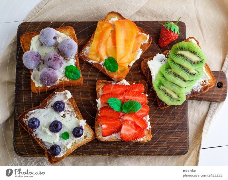 French toasts with soft cheese Cheese Fruit Bread Dessert Breakfast Wood Eating Above Soft Green Red White Strawberry kiwi Blueberry Dairy walnut persimmon