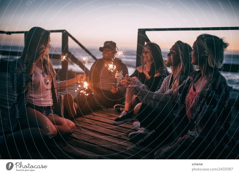 friends enjoying the sunset with sparkles on a pier Joy Happy Beautiful Freedom Summer Sun Ocean Man Adults Friendship Group Nature Sky Coast Smiling Love Sit