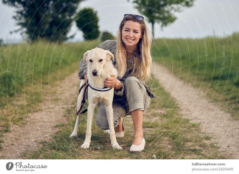 Happy young blond woman with her dog Lifestyle Beautiful Face Summer Woman Adults Friendship 1 Human being 18 - 30 years Youth (Young adults) Nature Animal