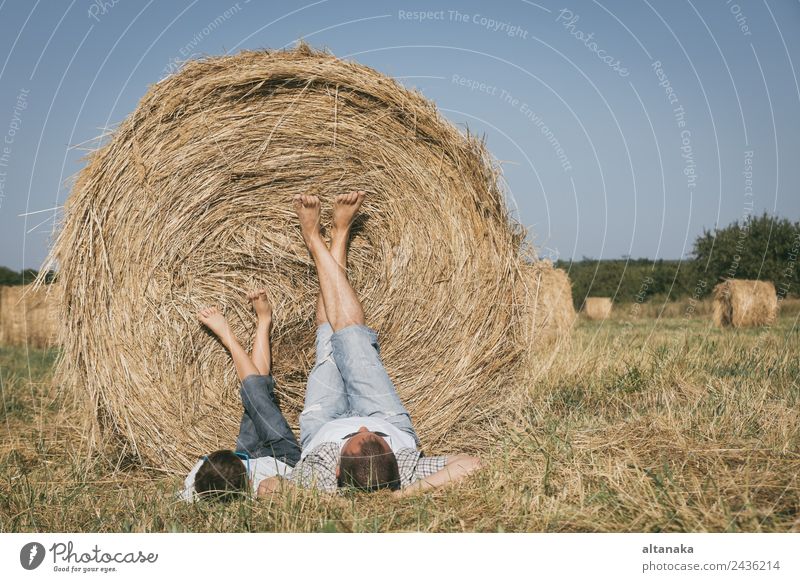 Father and son lying in the field Lifestyle Joy Happy Leisure and hobbies Playing Vacation & Travel Freedom Summer Sun Sports Child Human being Boy (child) Man