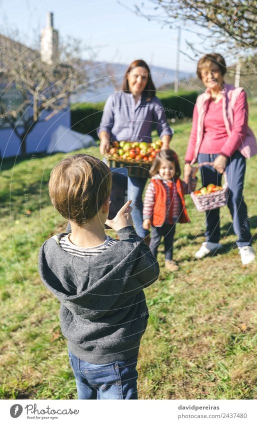 Boy taking photo to family with apples in basket Fruit Apple Lifestyle Joy Happy Leisure and hobbies Child Human being Boy (child) Woman Adults Man Mother