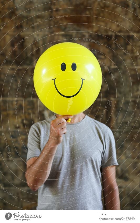 Seventh picture with yellow smiley Lifestyle Joy Leisure and hobbies Playing Man Adults 1 Human being 30 - 45 years 45 - 60 years Balloon Sign Smiley To hold on