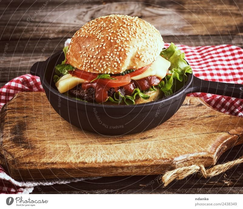 burger with a meatball Meat Cheese Vegetable Lettuce Salad Bread Roll Lunch Fast food Pan Table Wood Eating Fresh Large Delicious Green Red Black Hamburger Beef
