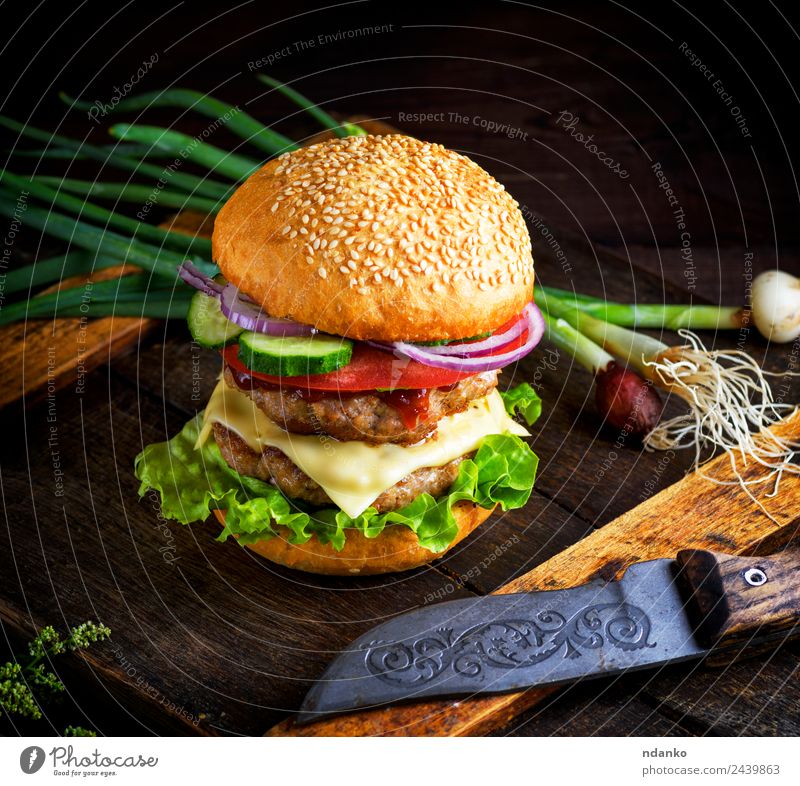 double cheeseburger with vegetables Meat Cheese Vegetable Bread Roll Lunch Fast food Knives Table Restaurant Wood Eating Fresh Large Delicious Green Red Black