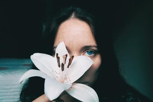 a girl with a white lily covering an eye Lifestyle Beautiful Face Relaxation Calm Human being Feminine Young woman Youth (Young adults) Woman Adults 1