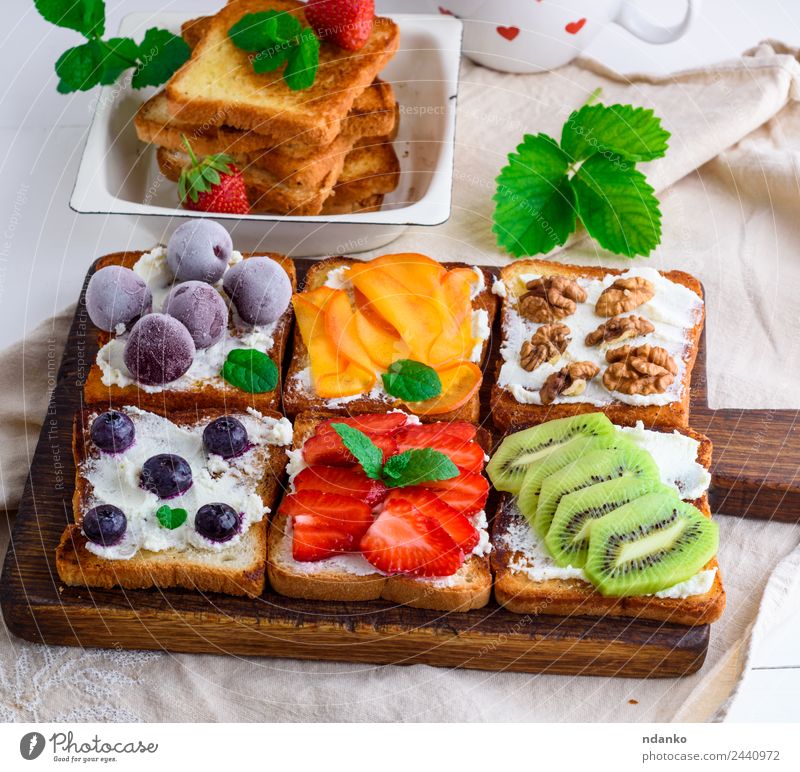 French toasts with soft cheese Cheese Fruit Bread Breakfast Wood Above Soft Green Red White Strawberry kiwi Blueberry Dairy walnut persimmon Cherry Sandwich