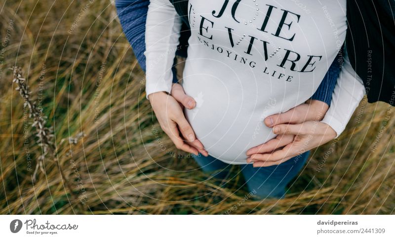Pregnant with partner hugging and holding belly Lifestyle Beautiful Human being Woman Adults Man Mother Couple Hand Nature Landscape Grass Meadow Aircraft Touch