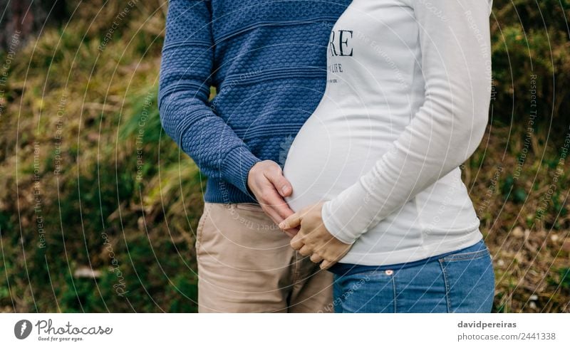 Pregnant with partner holding belly Lifestyle Human being Woman Adults Man Mother Couple Hand Nature Landscape Autumn Grass Meadow Clothing Shirt Jeans Sweater