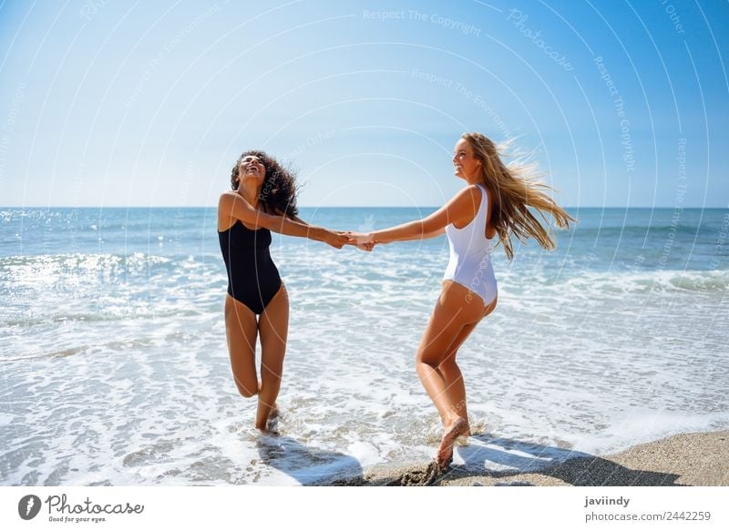 Two women with their hands caught on the beach Lifestyle Joy Leisure and hobbies Vacation & Travel Summer Beach Human being Feminine Young woman