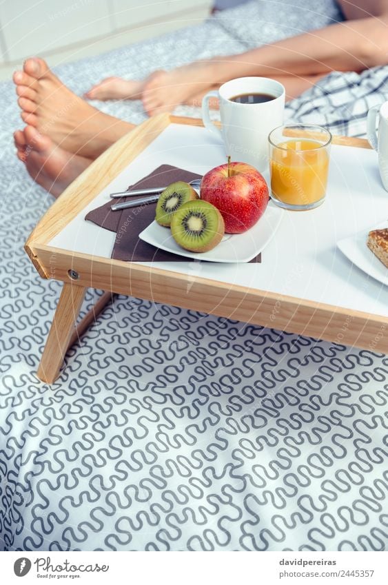 Healthy breakfast on tray and couple legs in background Fruit Apple Breakfast Juice Coffee Lifestyle Happy Relaxation Leisure and hobbies Bedroom Woman Adults