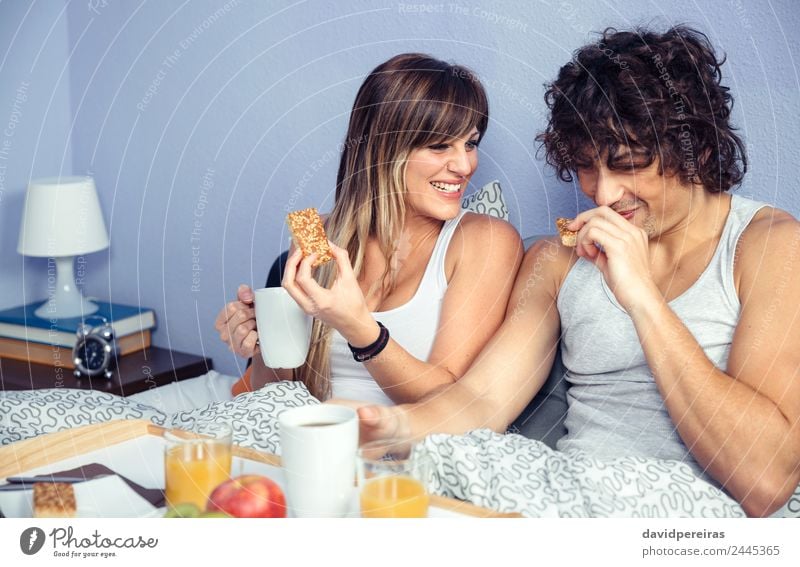 Couple laughing and having breakfast in bed at home Fruit Apple Breakfast Juice Coffee Lifestyle Happy Beautiful Relaxation Leisure and hobbies Bedroom Woman