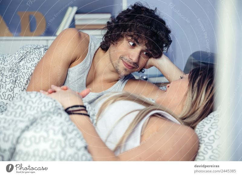 Man looking to beautiful woman lying on bed Lifestyle Happy Beautiful Relaxation Bedroom Woman Adults Family & Relations Couple Smiling Love Sleep Sex Authentic