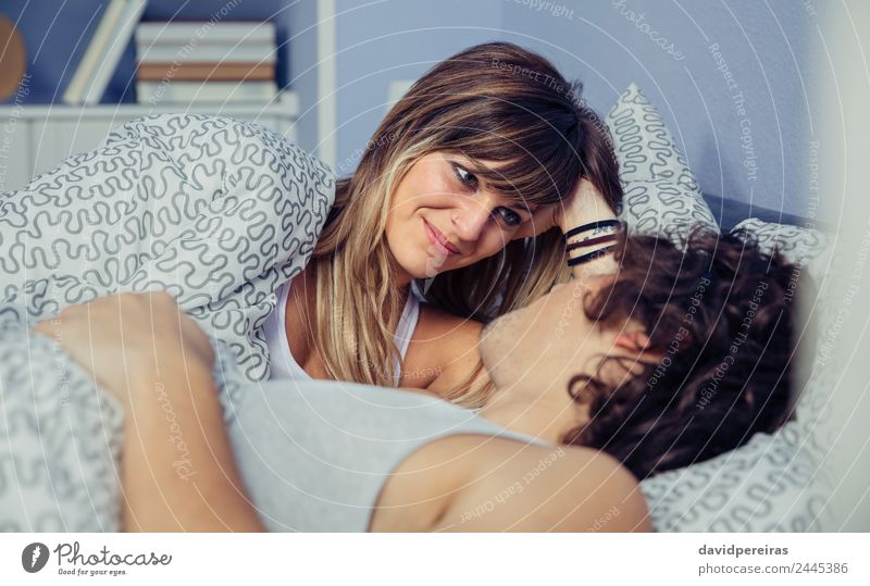 Beautiful woman looking to man lying on bed Lifestyle Happy Relaxation Bedroom Woman Adults Man Family & Relations Couple Smiling Love Sleep Sex Authentic