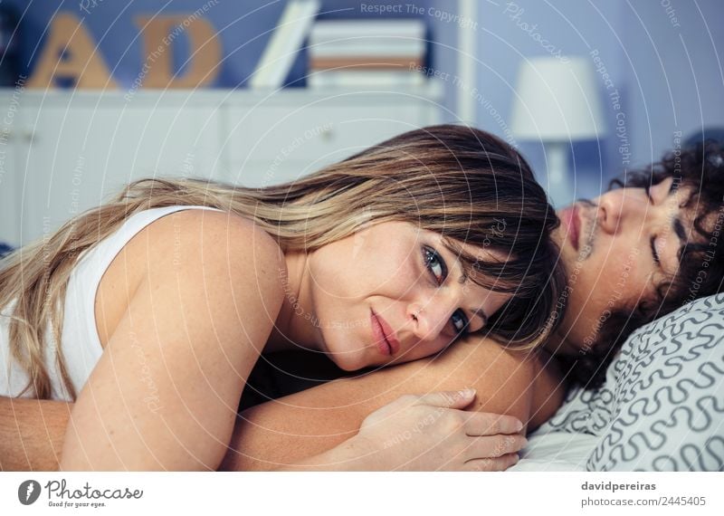 Young couple in love embracing lying over a bed Lifestyle Happy Beautiful Relaxation Bedroom Woman Adults Man Family & Relations Couple Love Sleep Sex Dream