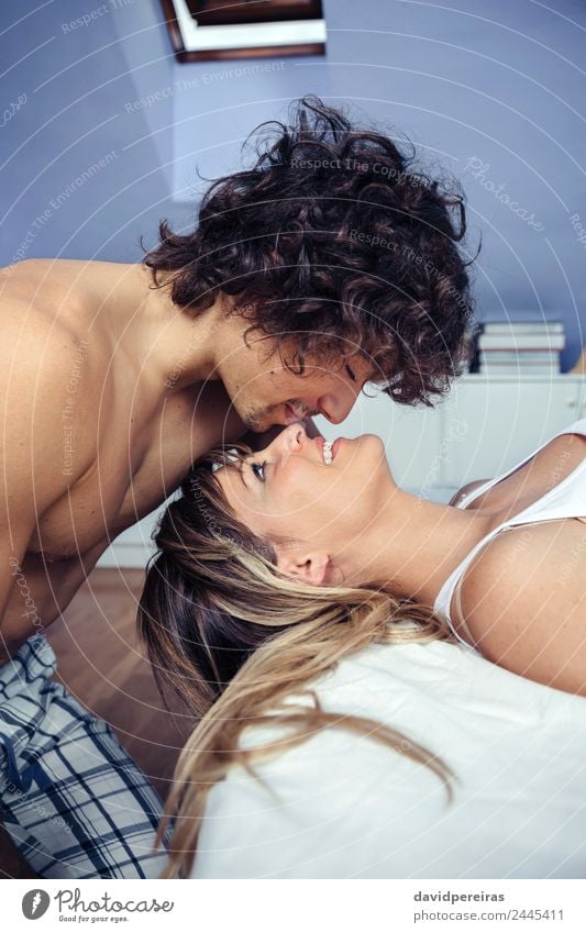 Young man kissing to beautiful woman lying on bed Lifestyle Happy Beautiful Relaxation Bedroom Woman Adults Man Family & Relations Couple Kissing Love Sleep Sex