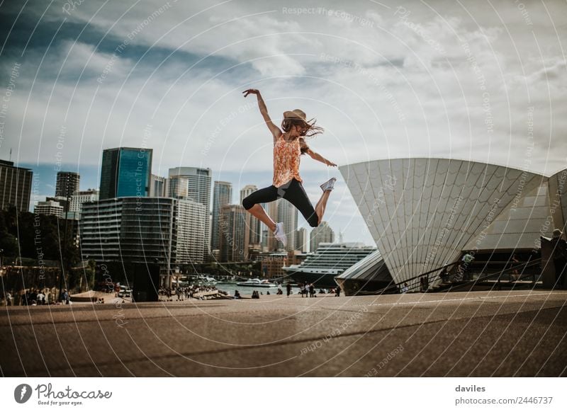 Thin girl jumping with energy with Sydney cityscape and Opera House in the background. Lifestyle Joy Leisure and hobbies Vacation & Travel Tourism Trip