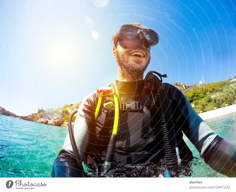 Happy man wearing diving clothes and equipment, smiling while get out of the water in the beach. Lifestyle Joy Face Relaxation Leisure and hobbies