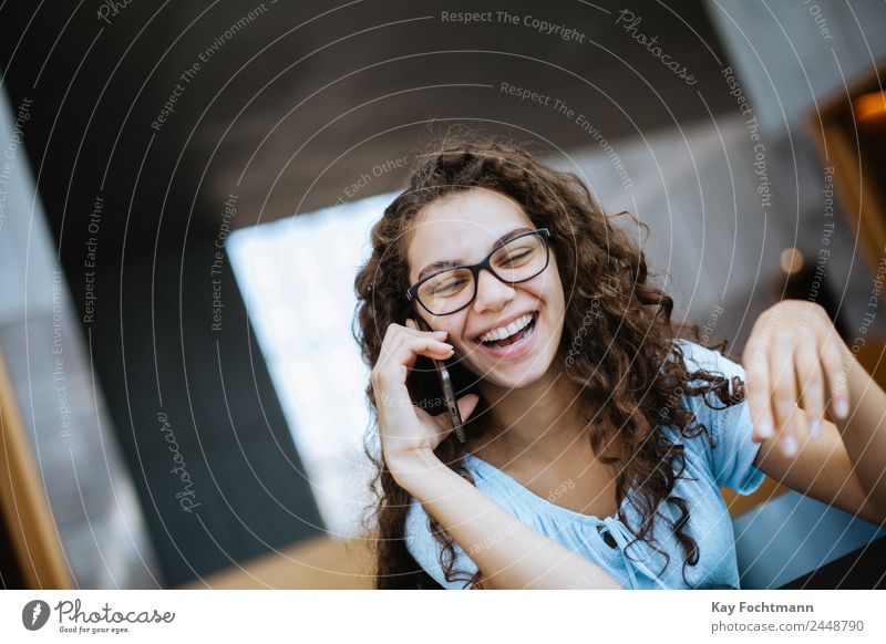 Young woman with curly hair laughs during a phone call Lifestyle Joy Beautiful Well-being Leisure and hobbies Living or residing Flat (apartment) Study