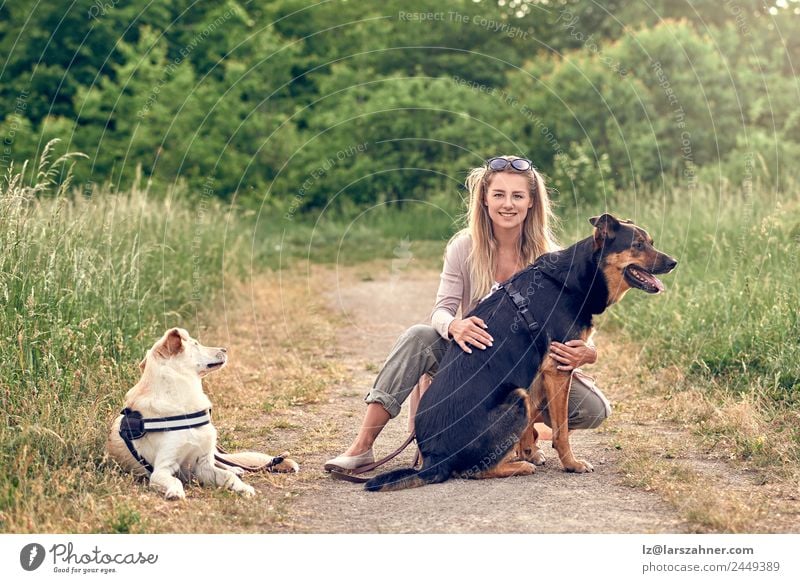 Happy blond woman with her two loyal dogs Beautiful Leisure and hobbies Summer Woman Adults Friendship 1 Human being 18 - 30 years Youth (Young adults)