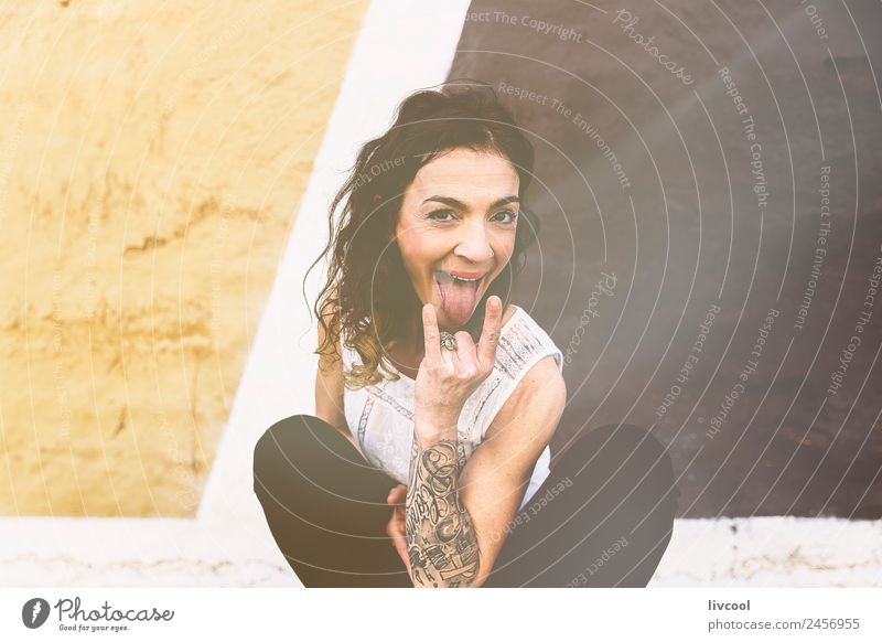 woman in irreverent pose Lifestyle Happy Beautiful Face Relaxation Calm Human being Feminine Woman Adults 1 45 - 60 years Art Facade Street Tattoo Piercing Curl