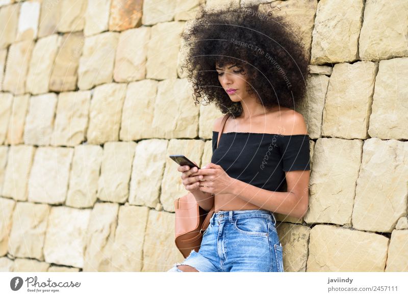 Serious black woman with afro hair looking at her smart phone outdoors. Lifestyle Style Beautiful Hair and hairstyles Telephone PDA Technology Human being