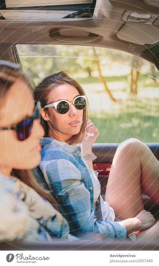 Two young women resting sitting inside of car Lifestyle Joy Happy Beautiful Relaxation Leisure and hobbies Vacation & Travel Trip Summer Sun Camera Human being