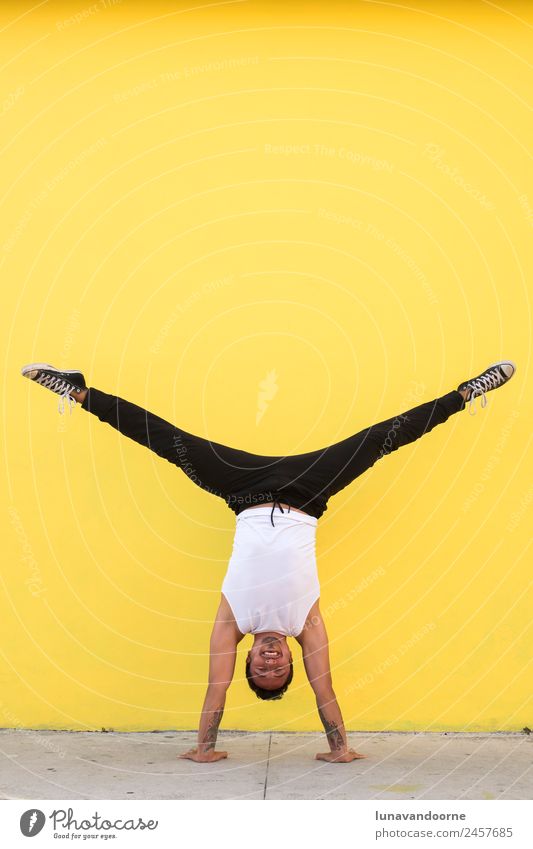 Man practicing yoga, handstand against a yellow wall Lifestyle Joy Athletic Fitness Well-being Sports Sports Training Track and Field Yoga Dance Human being