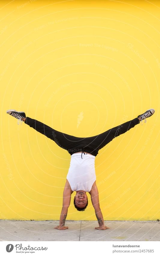 Man practicing yoga, handstand on a yellow wall Lifestyle Joy Athletic Fitness Well-being Sports Sports Training Track and Field Yoga Dance Human being
