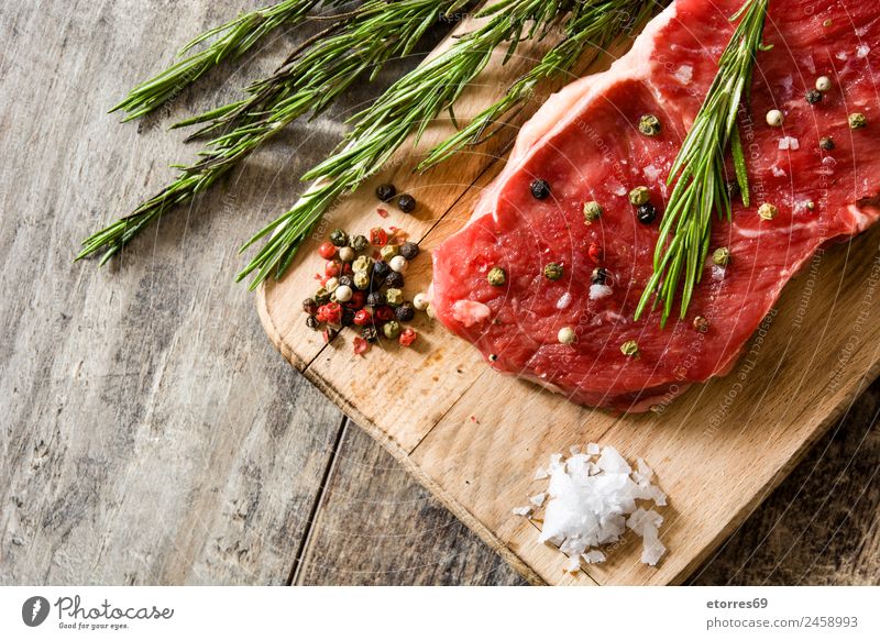 Raw beef steak with spicy ready to be cooked on wooden table Food Meat Nutrition Eating Lunch Dinner Green Red Beef Steak Food photograph Rosemary Pepper Spicy