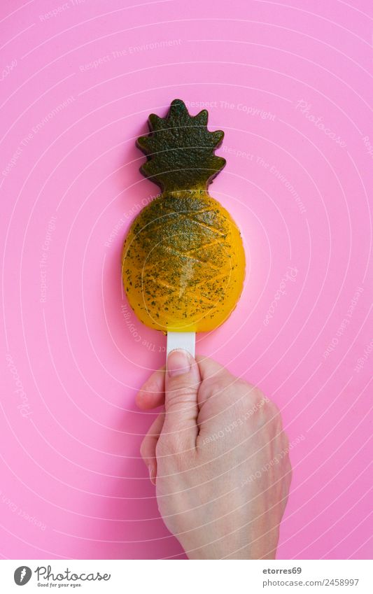 Hand holding pineapple popsicle on pink background. Top view Food Dessert Ice cream Candy Organic produce Yellow Pink Pineapple Summer Fruit Snack Cold